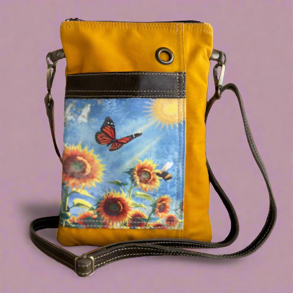 Yellow crossbody bag with a sunflower and butterfly design on a white background