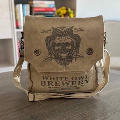 off white repurposed military canvas messenger bag with 'White Owl Brewery' print on the front with an owl and skull image
