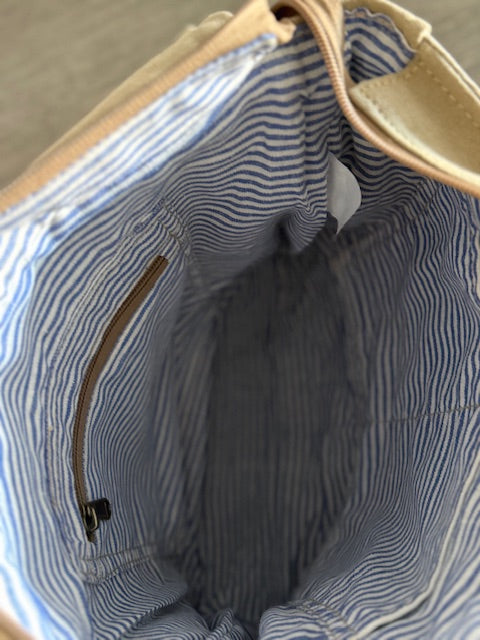 Close-up of a blue and white striped fabric lining of our white owl brewery messenger bag