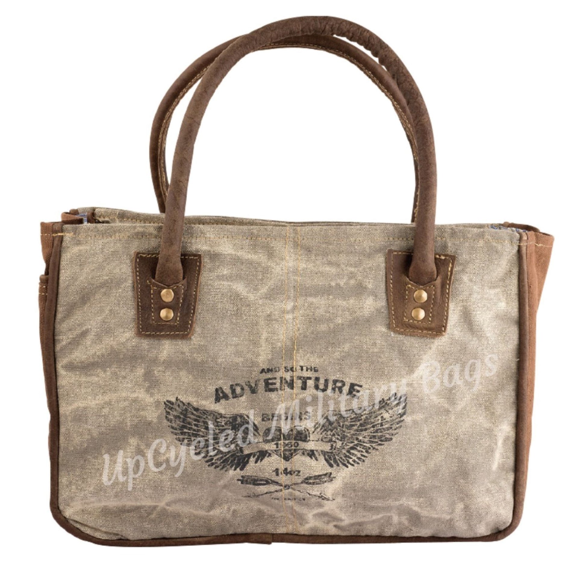 The UpCycled Adventure Tote is made from repurposed military tent and tarp canvas. Along with an image of Angel Wings the bag says: And So the Adventure Begins. This purse is strong and sturdy. It is ready to go on your next adventure but durable enough to make every day an adventure. Perfect Purse / Handbag but also large enough to take as a small travel tote. Dimensions are 13" x 9" x 4". Features: Antique Brass Accents, Top Zippered Closure