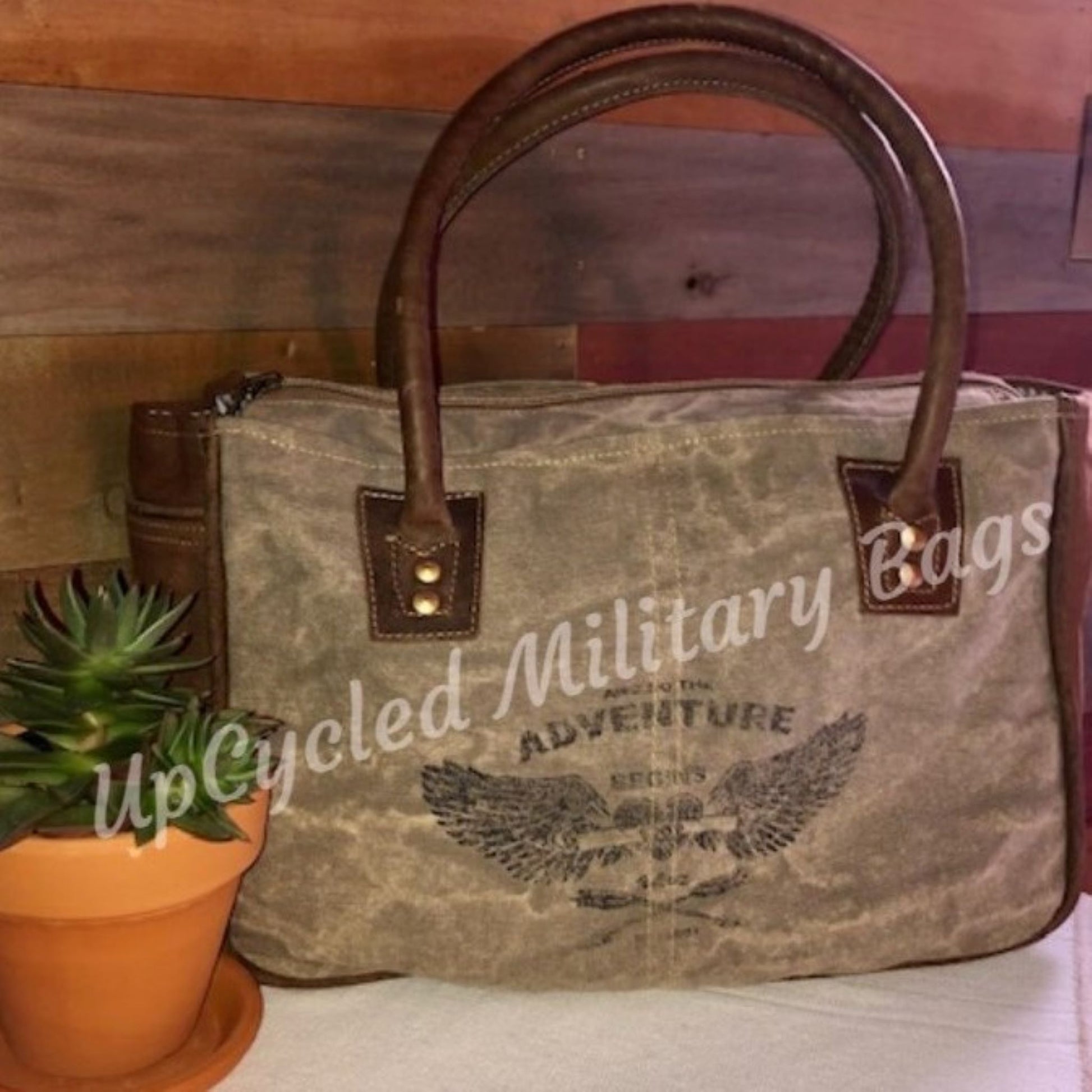 The UpCycled Adventure Tote is made from repurposed military tent and tarp canvas. Along with an image of Angel Wings the bag says: And So the Adventure Begins. This purse is strong and sturdy. It is ready to go on your next adventure but durable enough to make every day an adventure. Perfect Purse / Handbag but also large enough to take as a small travel tote. Dimensions are 13" x 9" x 4". Features: Antique Brass Accents, Top Zippered Closure