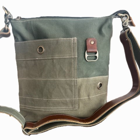 A recycled military canvas crossbody bag in muted green with a brown leather strap and metal hardware.