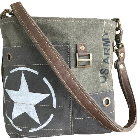Green military-style bag with star emblem and brown strap against a brick wall background