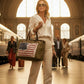 Recycled Military Weekender Tote Bag with American Flag front snap pocket being carried by a chic woman in a train terminal.