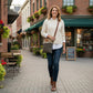 Green and Tan Recycled Military Canvas crossbody bag being worn by a woman near a coffee shop.