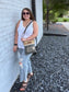 our peace love dogs custom print green and tan crossbody with fringe worn as a shoulder bag.