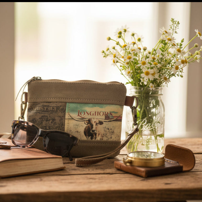 Repurposed Military Canvas wristlet with 'Longhorn' design and sunglasses on a rustic table.