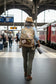 Recycled military backpack with world travel stamp designs being worn by a woman photographer while traveling