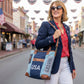 woman carrying a USA Tote bag crafted from recycled military canvas at a small town patriotic event